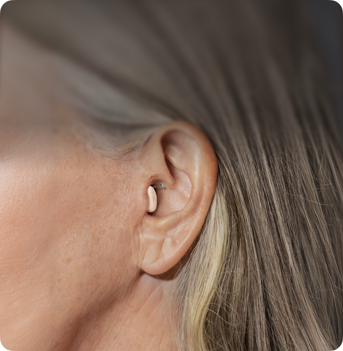 Close-up of a person's ear with hair with atom air hearing device 
