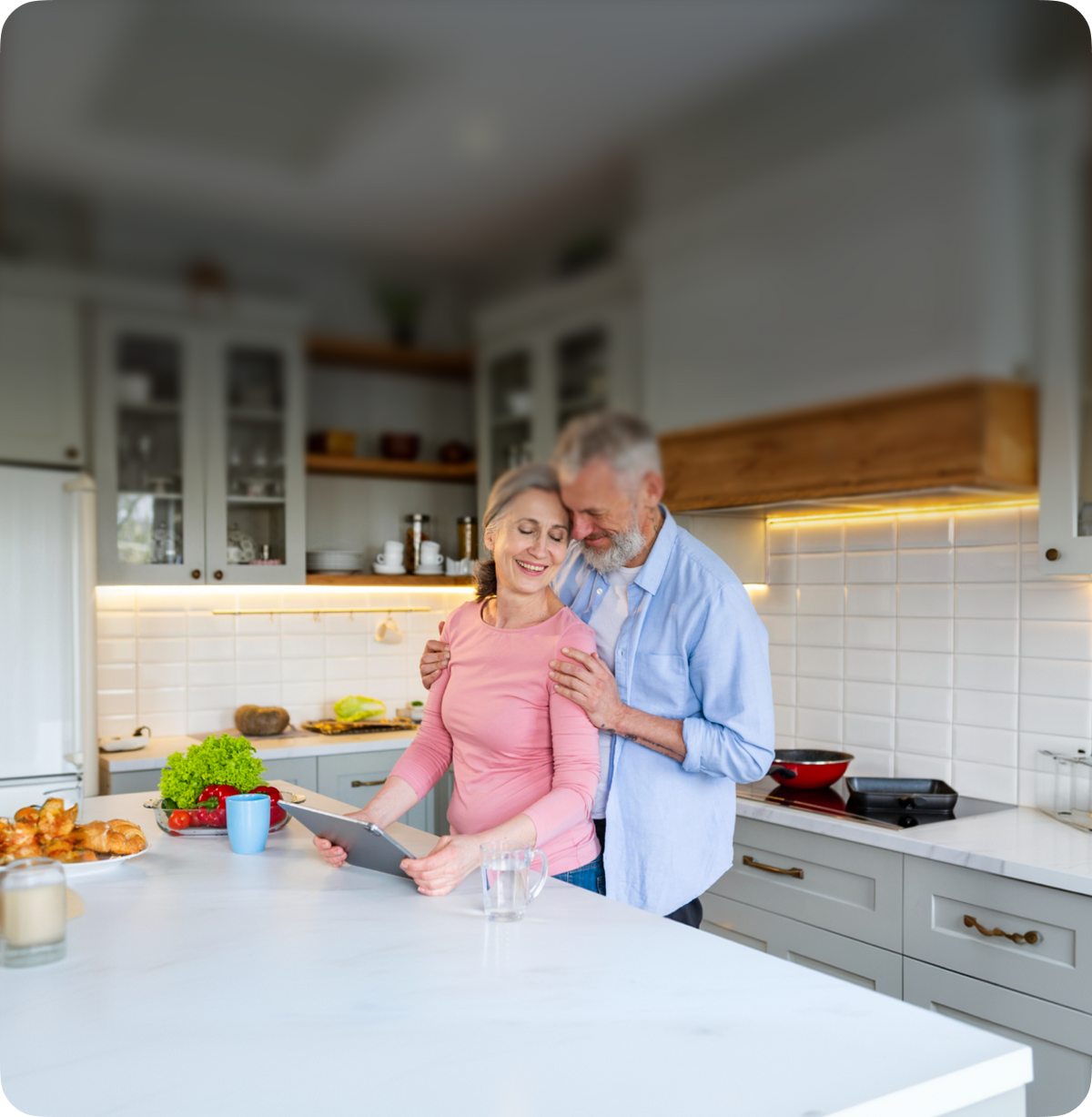 Couple in a modern kitchen using a tablet device.